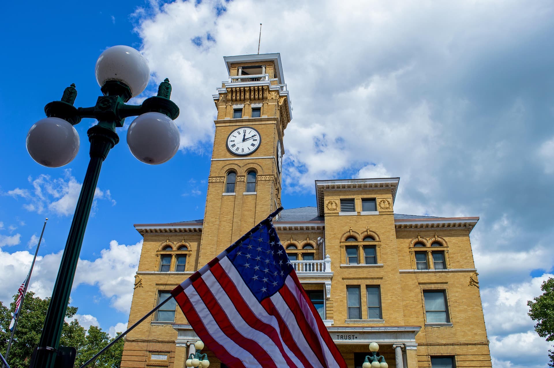A historic Texas county courthouse with a clock tower and an American flag